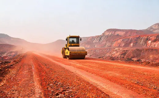 Single drum soil compactor on red mining haul road