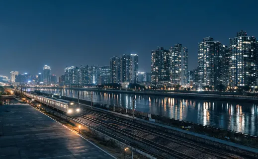 Urban mill and fill paving train beside riverfront towers